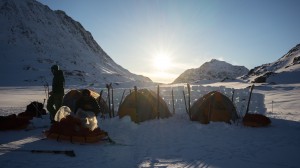 Tents behind the snow wall at sunset, Greenland